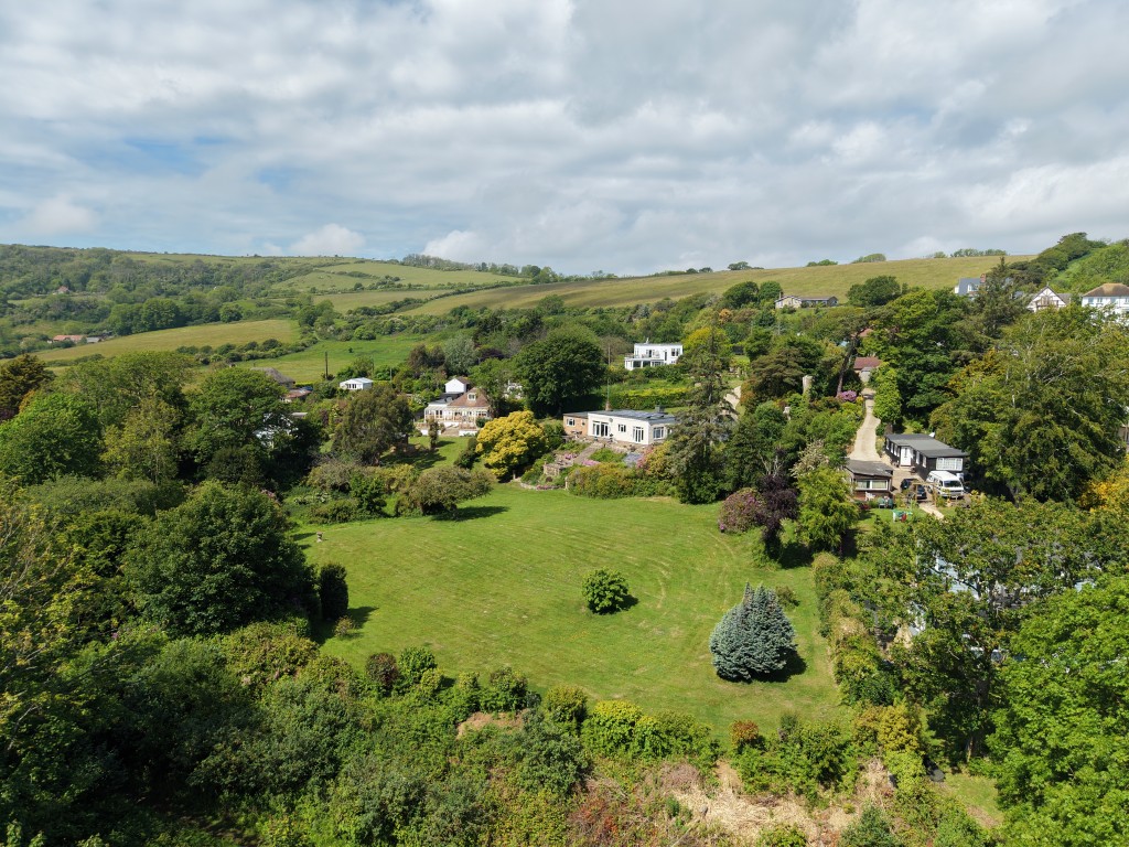 Lot: 142 - DETACHED BUNGALOW WITH STRUCTURAL DAMAGE AND ALMOST 2.5 ACRES WITH SEA VIEWS - The Bungalow and Gardens with the Downs Beyond